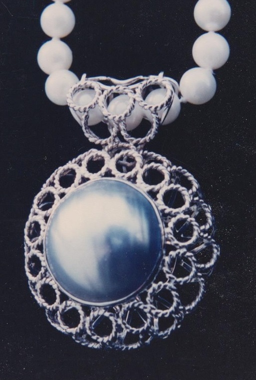 Hand wrought twisted wire gold pendant pearl enhancer.